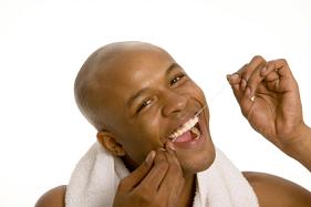 Young man flossing his teeth