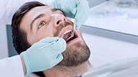 A dentist checks a teeth of a men