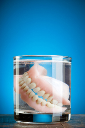 A pair of dentures in a glass of water